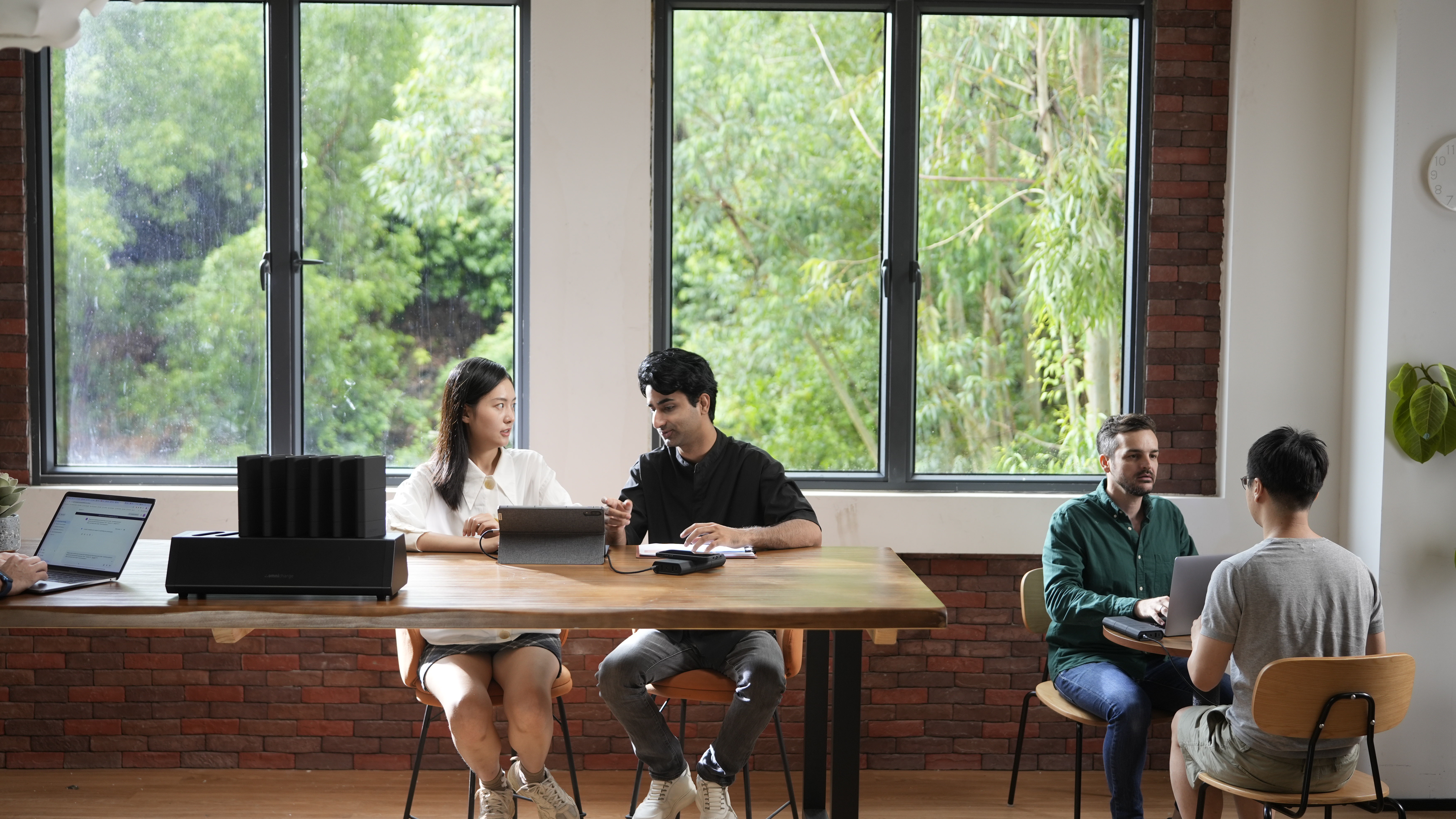 Estudiantes trabajando con laptops y baterías Omnicharge en un área común